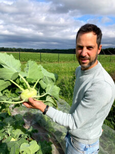 Bioboer Steve oogst een verse koolrabi op zijn veld in Hechtel, klaar voor de groentepakketten van Rauwe Kost